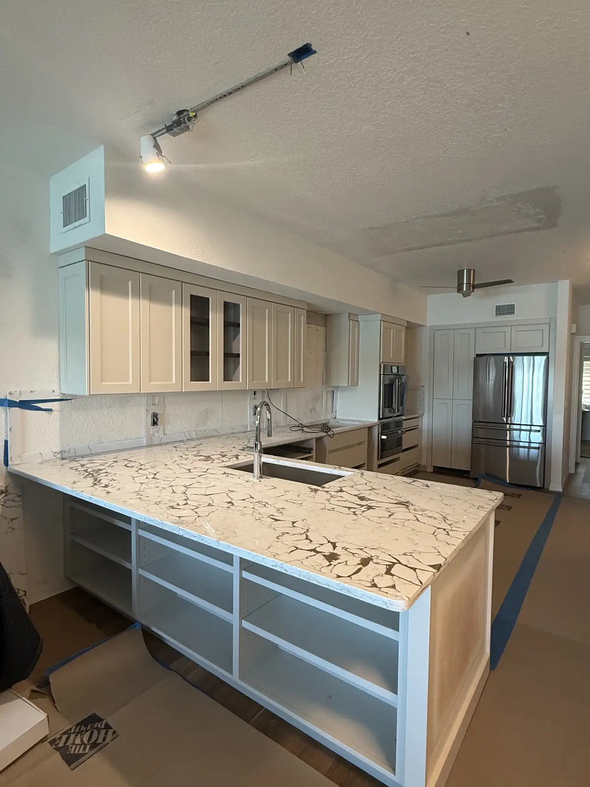 Granite island in a cream cabinetry kitchen remodel by Venet LLC in Tampa Bay, Florida