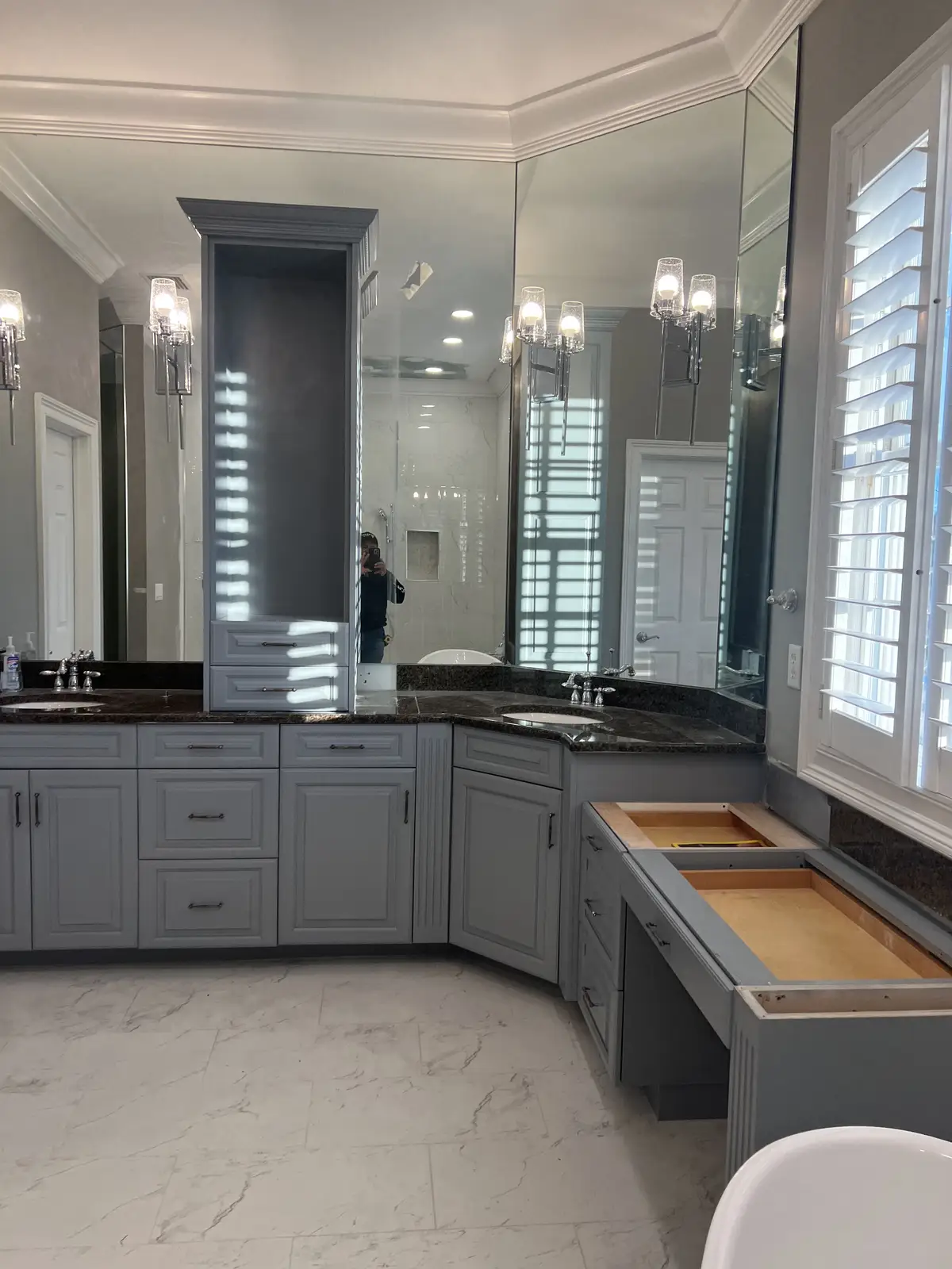 Gray double vanity with black granite countertop and makeup station by Venet LLC in Tampa Bay, Florida