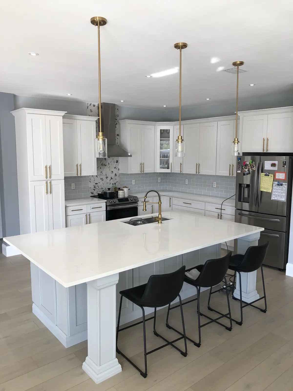 White quartz island with bar seating in a white kitchen by Venet LLC in Tampa Bay, Florida