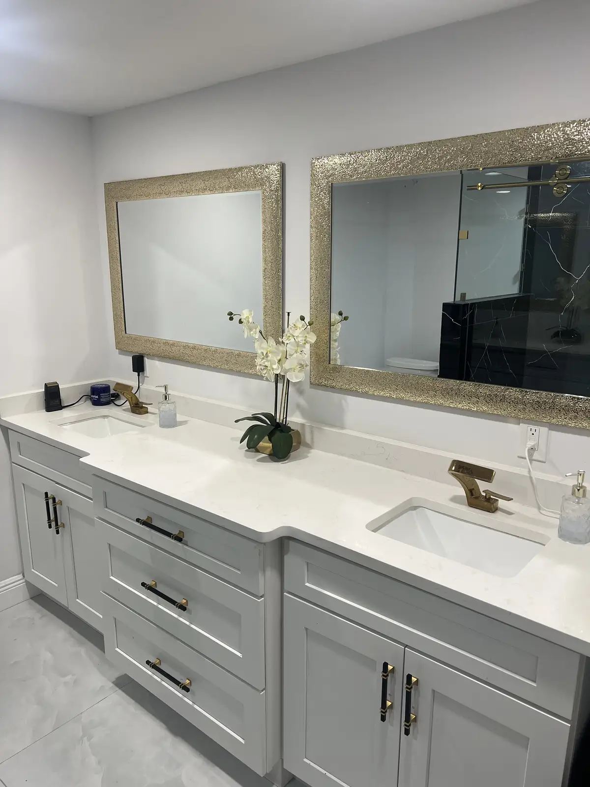 Gray double vanity with quartz countertop and gold fixtures by Venet LLC in Tampa Bay, Florida