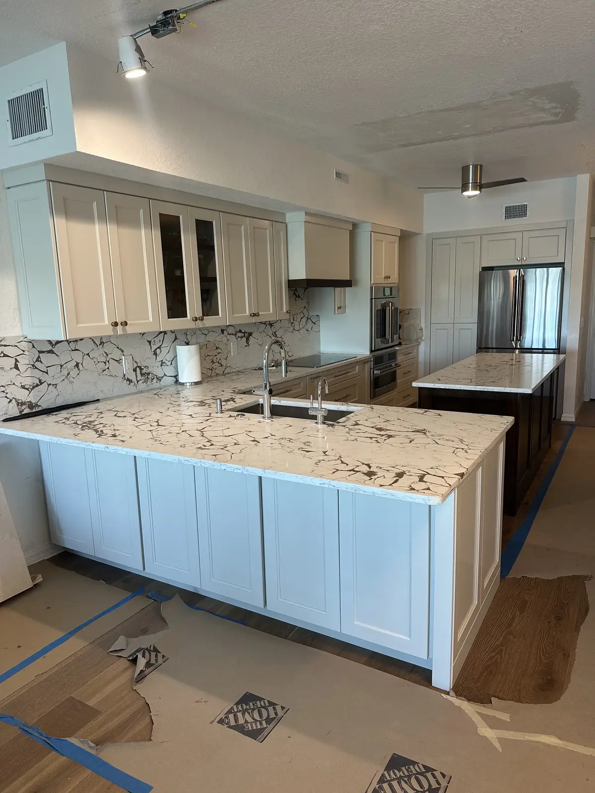 Granite countertops with white cabinets and center island by Venet LLC in Tampa Bay, Florida