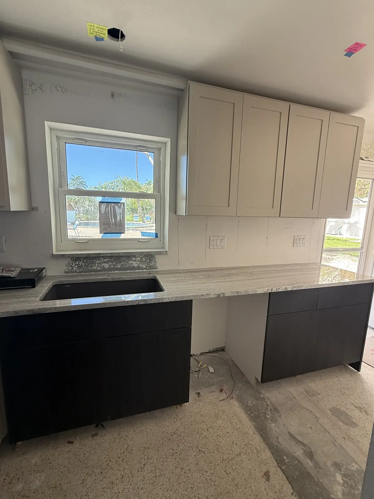 Two-tone kitchen with stone countertops and undermount sink by Venet LLC in Tampa Bay, Florida