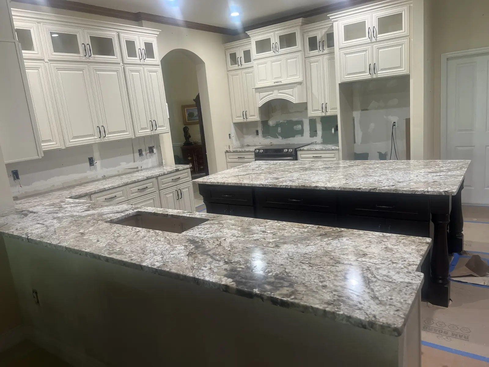 Granite perimeter countertops and backsplash in a white kitchen by Venet LLC in Tampa Bay, Florida