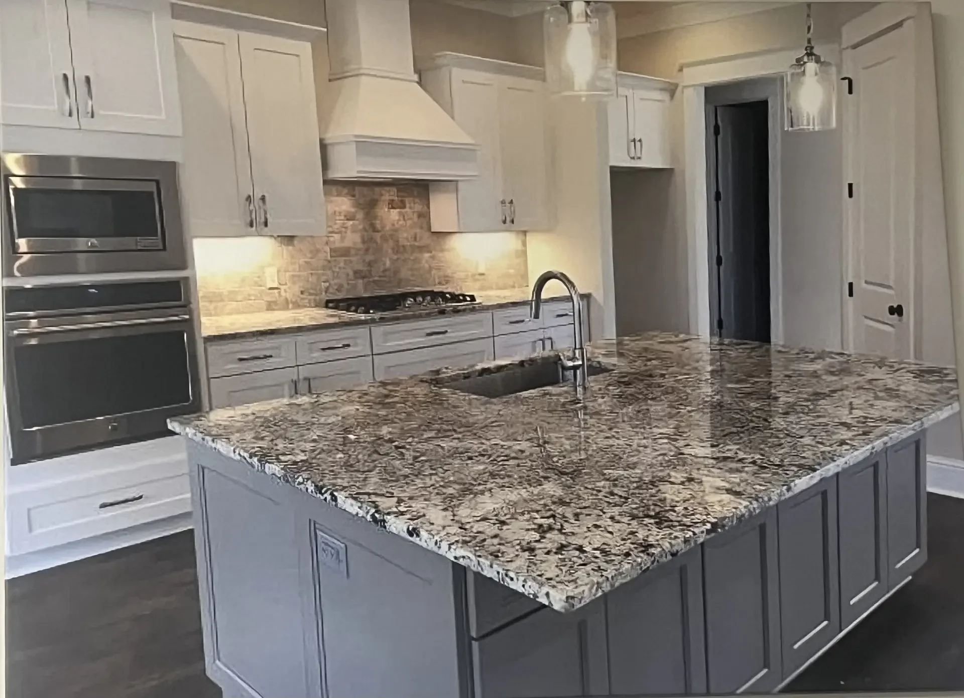 Kitchen remodel after: finished white cabinets, quartz countertops and stainless steel appliances